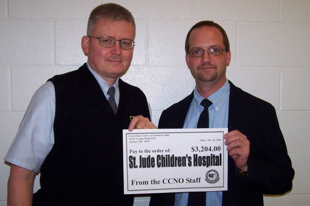 PR Picture 2 (2) WEB - The Village Reporter DONATION ... CCNO Corrections Supervisor Pat Miller and Corrections Officer John Zimman holding a check to be presented to St. Jude Children’s Research Hospital. Supervisor Miller donated numerous handmade items for the raffle while Officer Zimman was the lucky recipient of several donated items.
