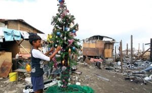 BATILO3 - The Village Reporter A resident puts the finishing touches on the community Christmas tree - Photo courtesy of George Tapan, Photographer - The Philipine Starweek