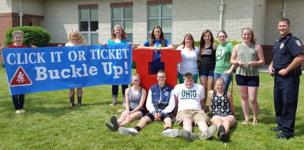 Hilltop HS 2016 WEB - The Village Reporter Champions with “Highest Seat Belt Usage Percentage” of 87.1% is Hilltop High School. Pictured Left to Right: Seated Front: Macey Kunkle, RyLee McCain, Ethan Dunson, Sydni Rivera. Standing with banner: Aubrie Calvin, Zoi Bauer, Johnnie Roth, Madisyn Undrwood, Danny Ackley, Layni Allport, MiKayla Eberly, Veronica Roth, Chief JR Jones, West Unity Police Department.