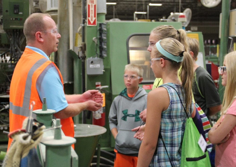 Students look on as David Meyer, Director of Quality Assurance and Continuous Improvement at Sauder Woodworking explains the processes needed to create a finished piece of furniture.