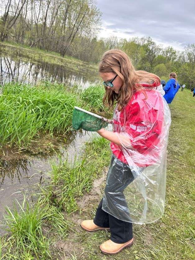 Stryker student inspects her catch at Camp Palmer