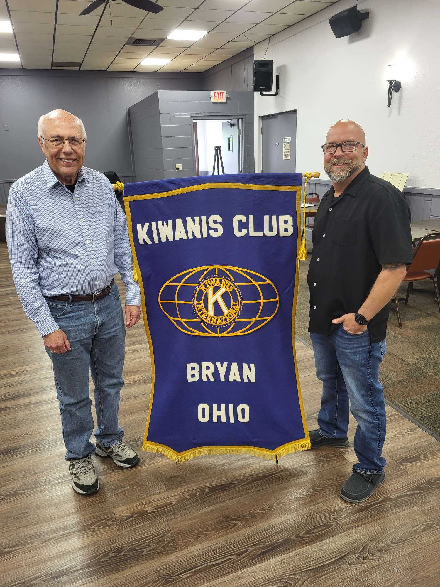 Kiwanis Club of Bryan members Ed Lyons (left) and Bernie Davis stand by the Club banner