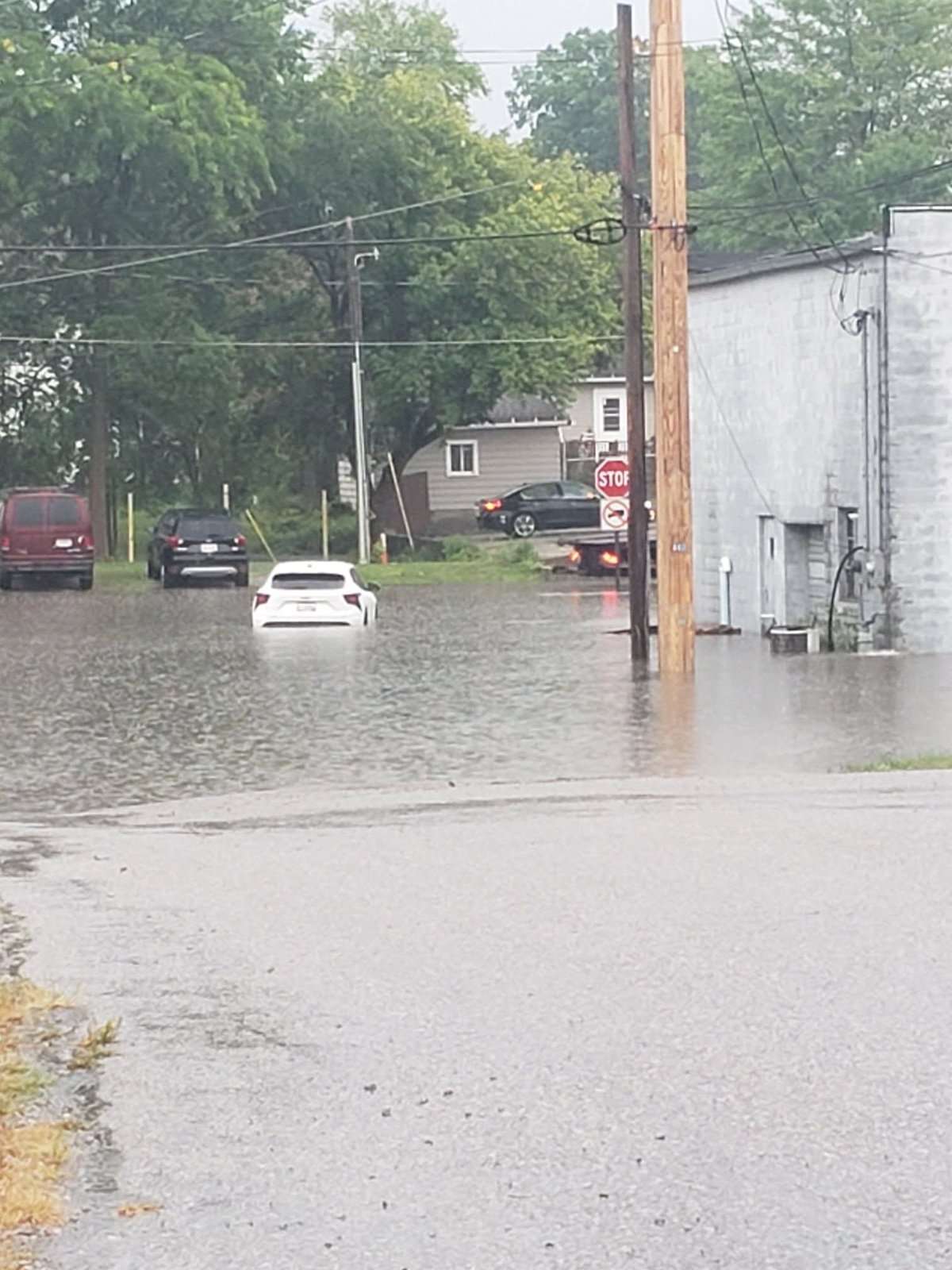 A car sits partially submerged in floodwater on a Montpelier-area street, July 17, 2026.