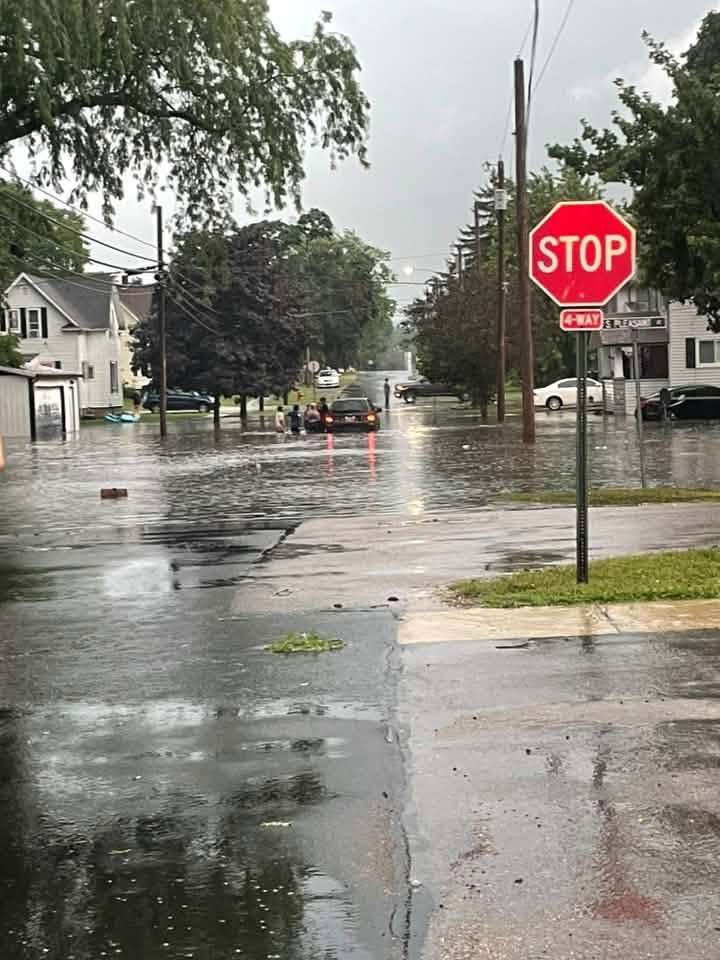 Floodwater and a stop sign on a Montpelier-area street after heavy rain, July 17, 2026.