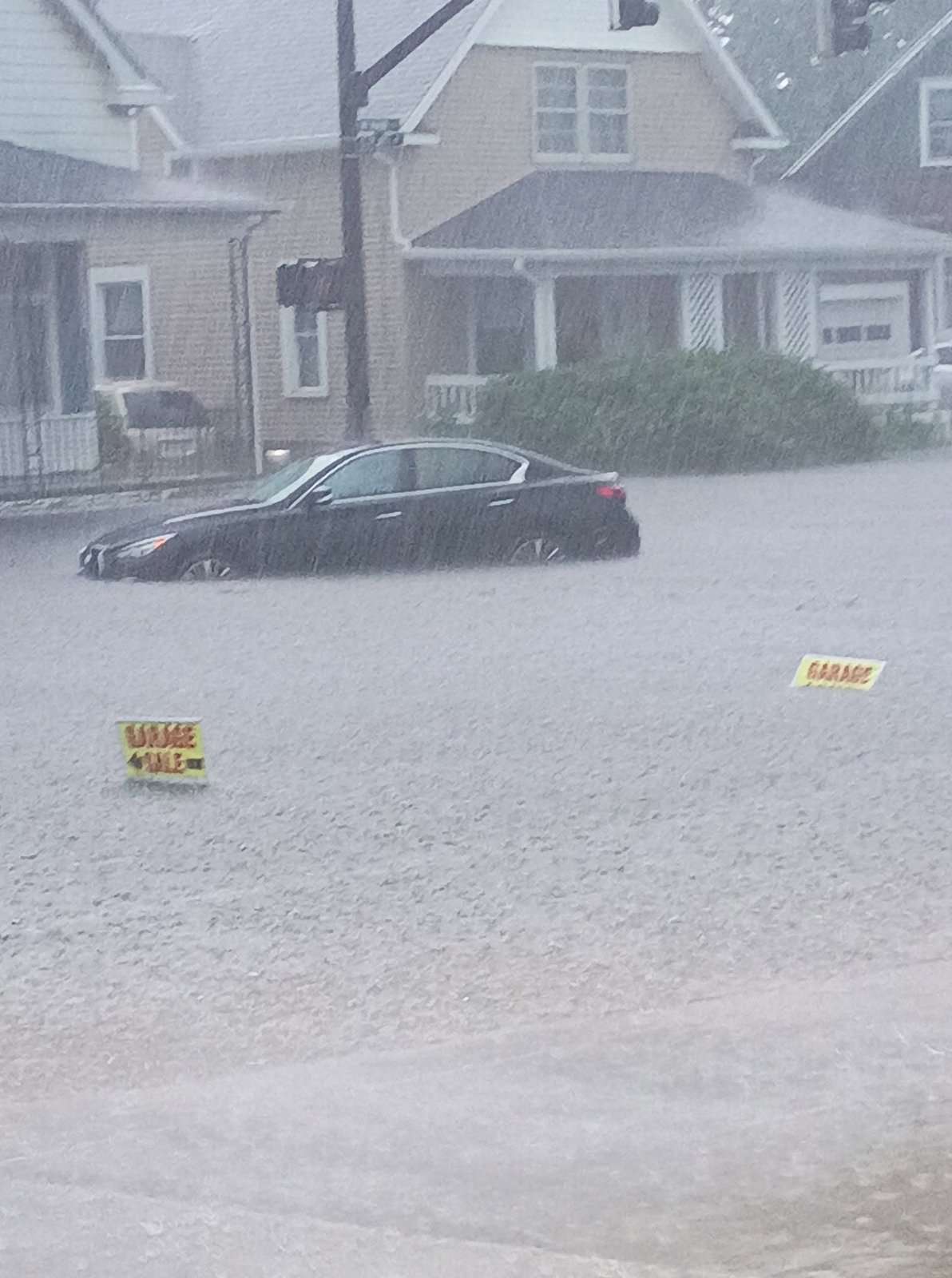 A car sits submerged in floodwater on a Montpelier-area street during heavy rain, July 17, 2026.