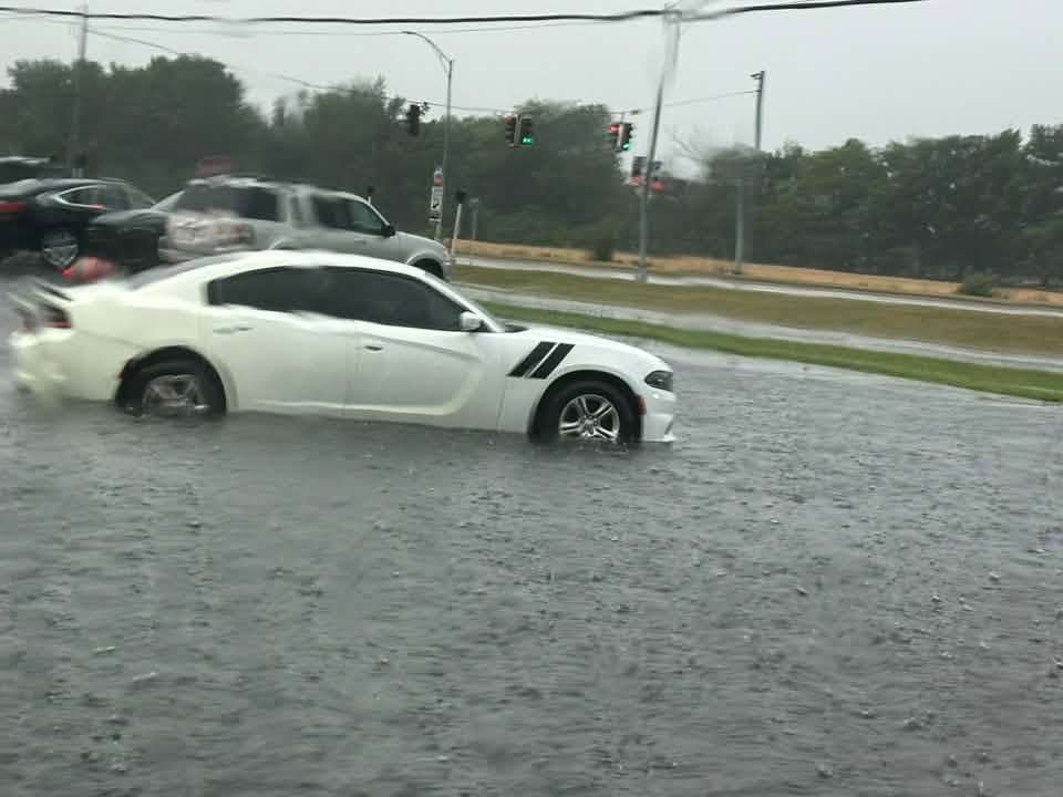 A car pushes through floodwater at a Montpelier-area intersection, July 17, 2026.
