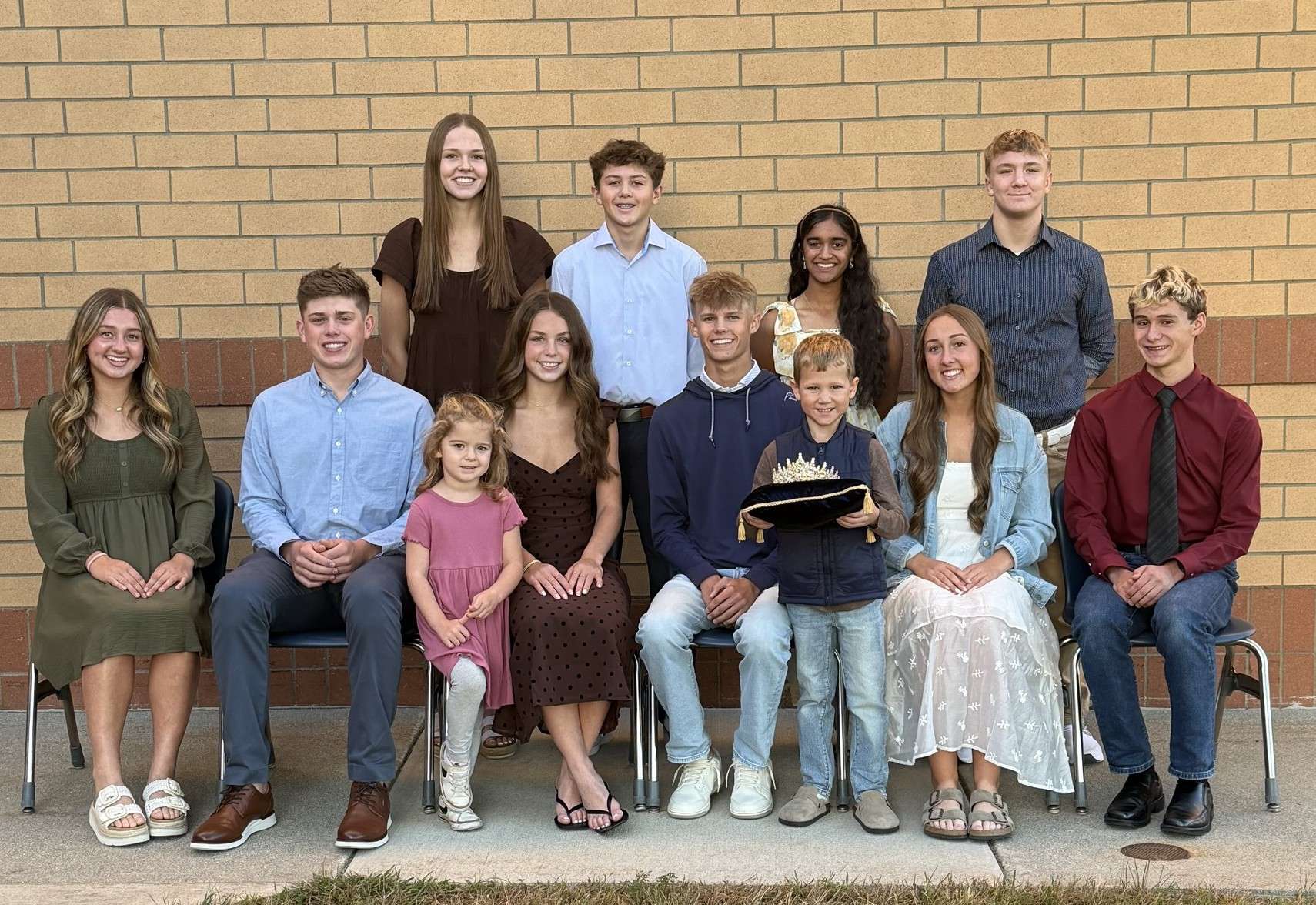 The 2026 Archbold High School Homecoming Court seated and standing in front of a brick wall