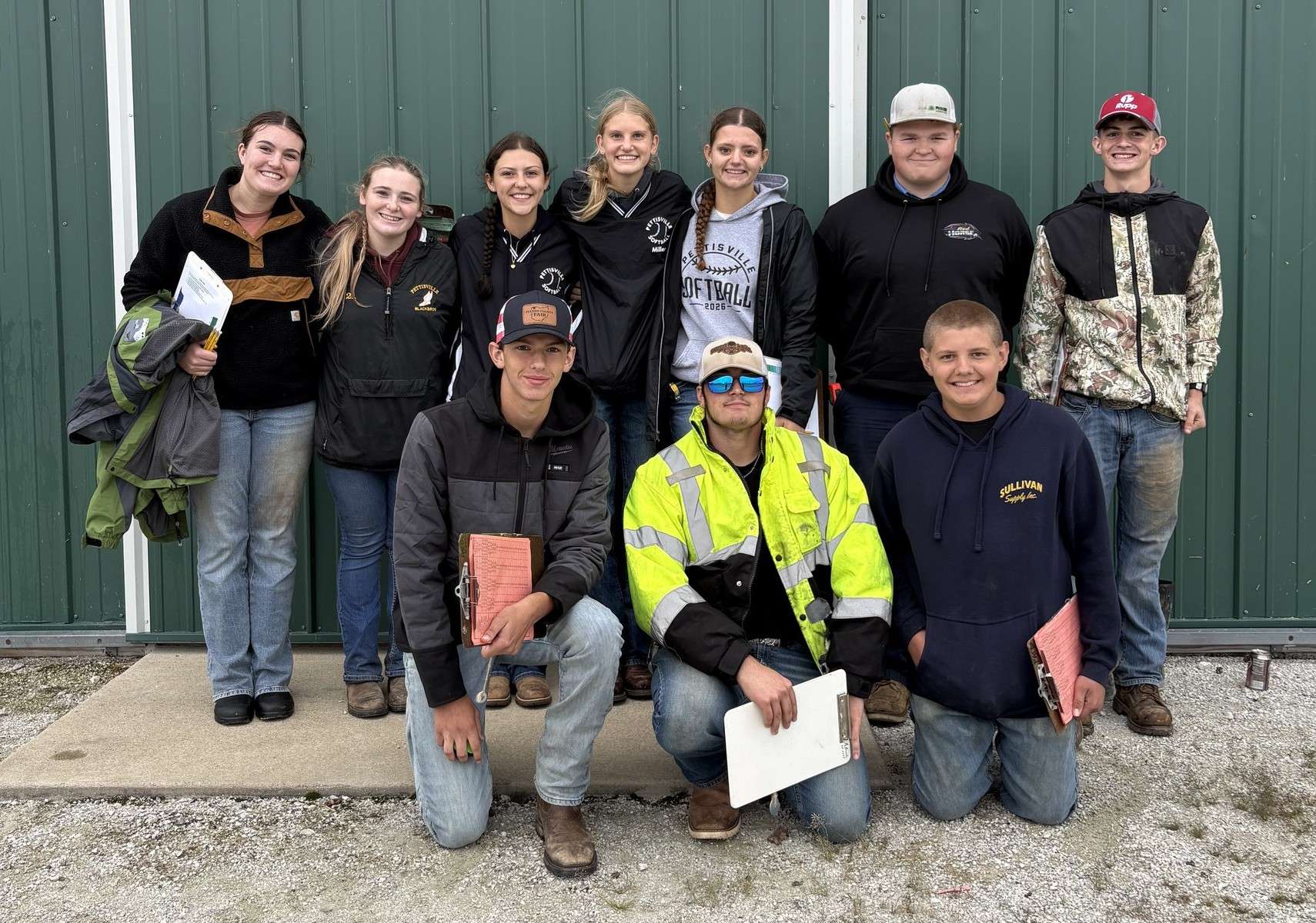 Ten Pettisville FFA members posed in front of a green building at the District 1 soils contest