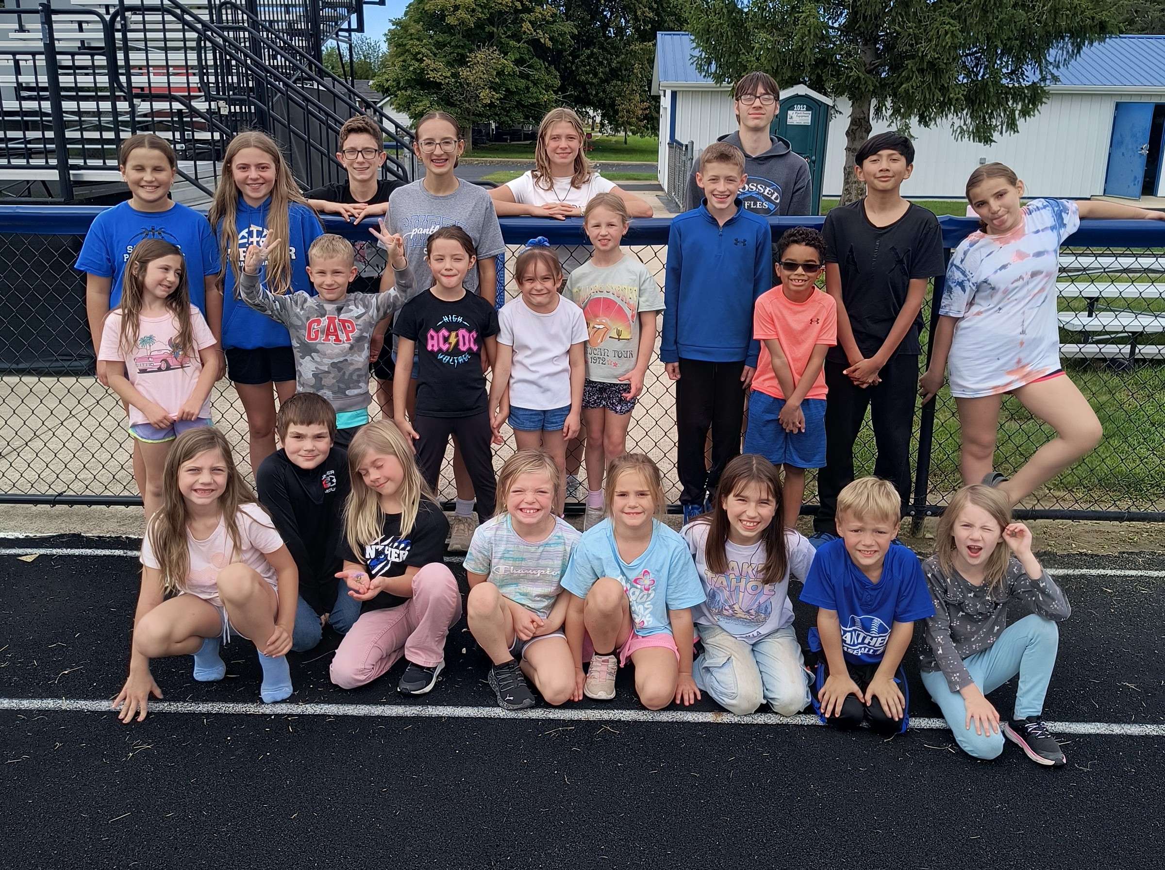 Stryker elementary students and cross country runners pose together at a Fun Run