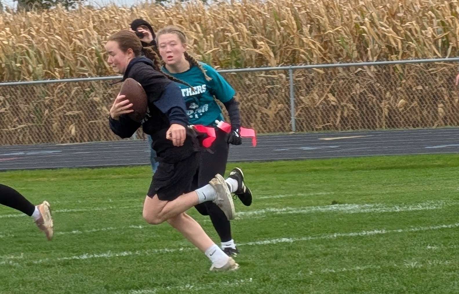Madison Cherry carries the ball while being pursued by Mikayla Guy