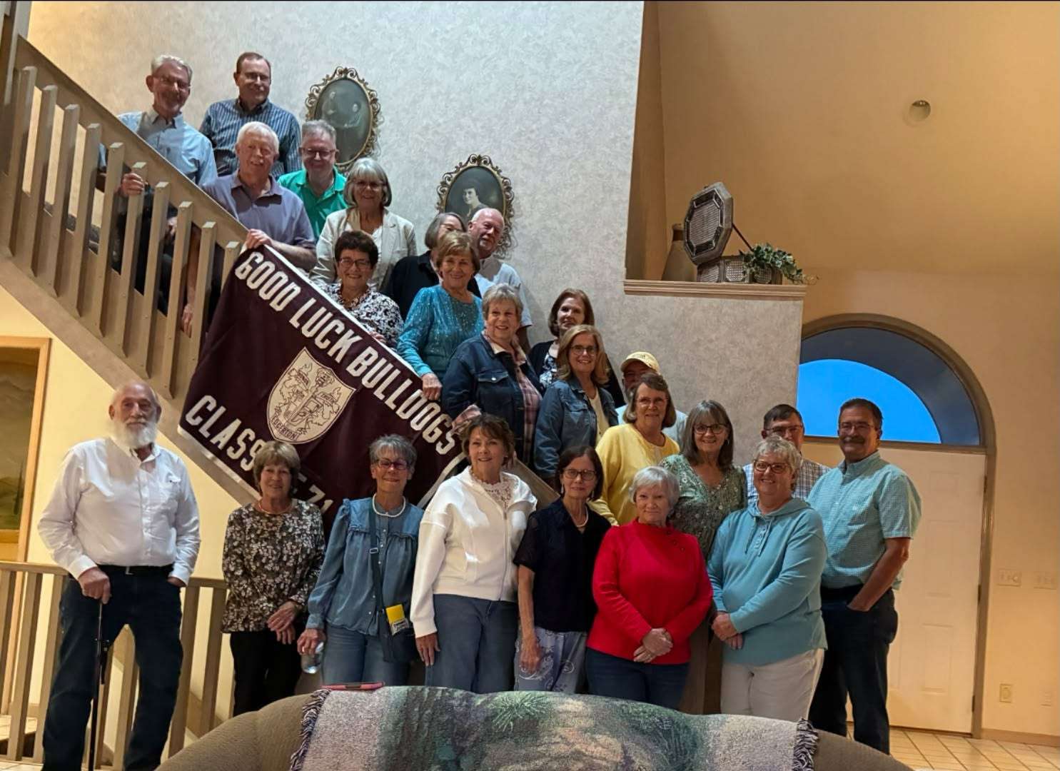 Edgerton High School Class of 1971 members on a staircase with their Good Luck Bulldogs Class of 71 banner