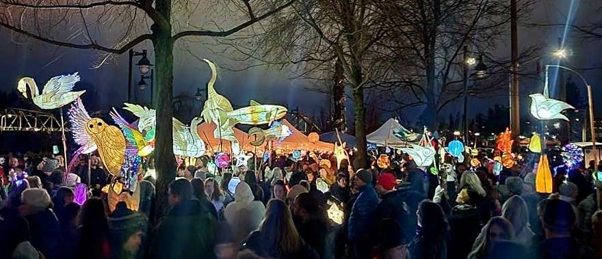 Lighted luminaries carried in a parade at night