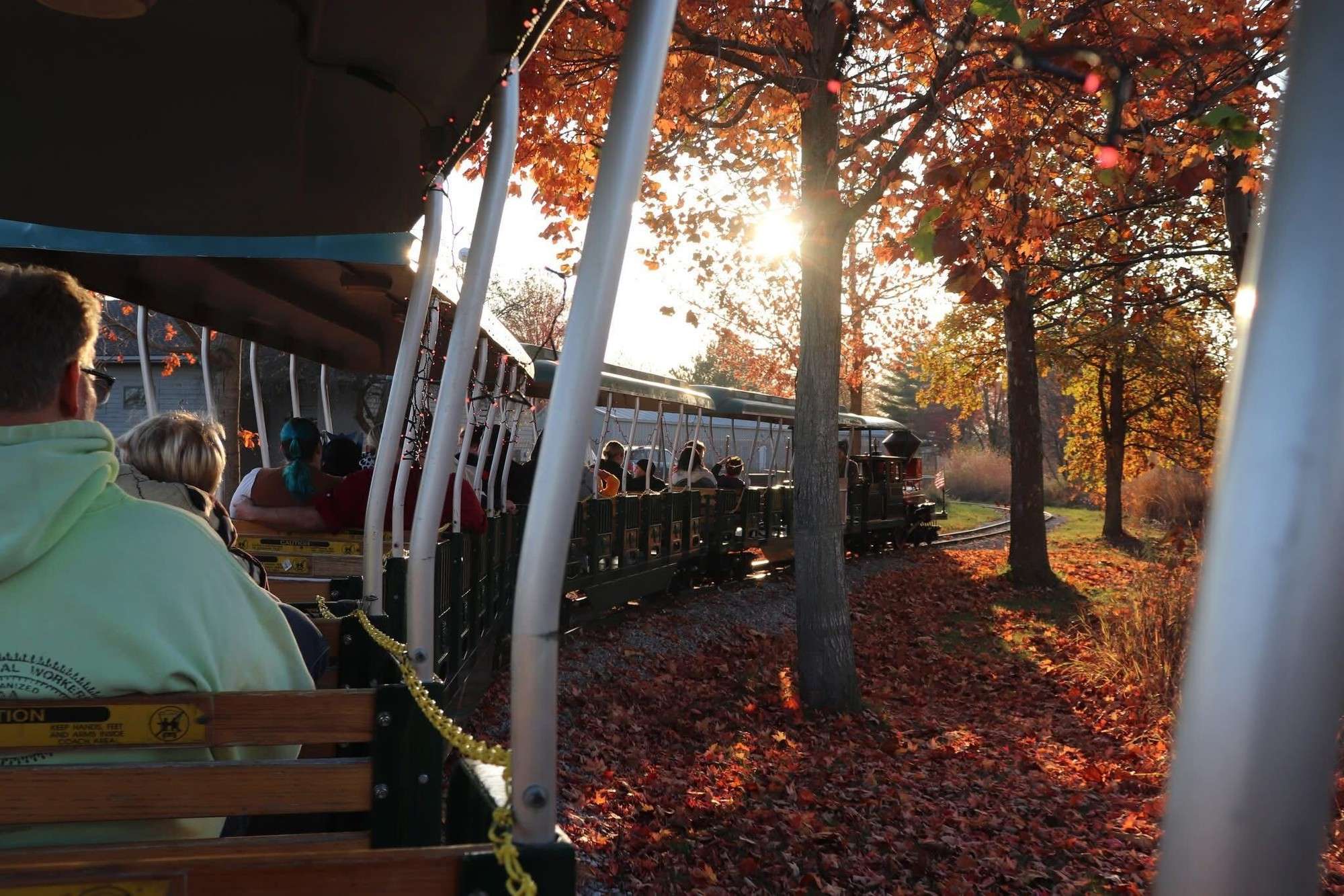 Passengers ride the train past autumn leaves at Sauder Village