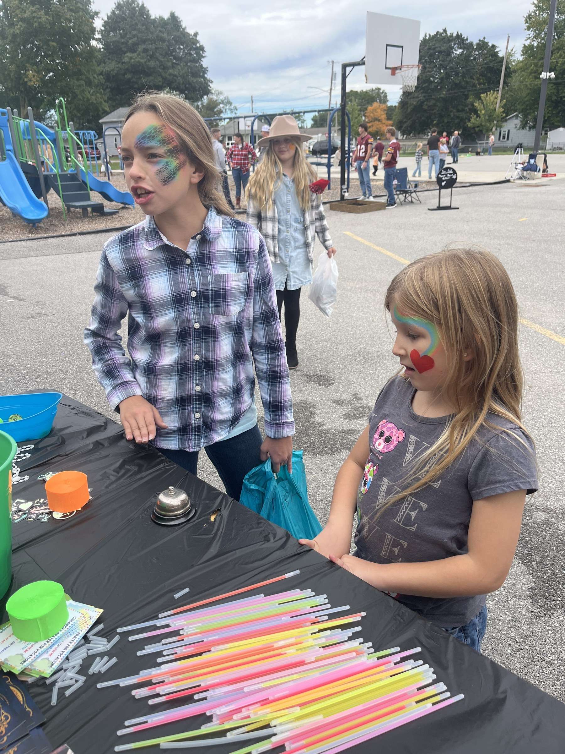 St. Mary School Grandparent Day carnival: two girls with face paint at a game table