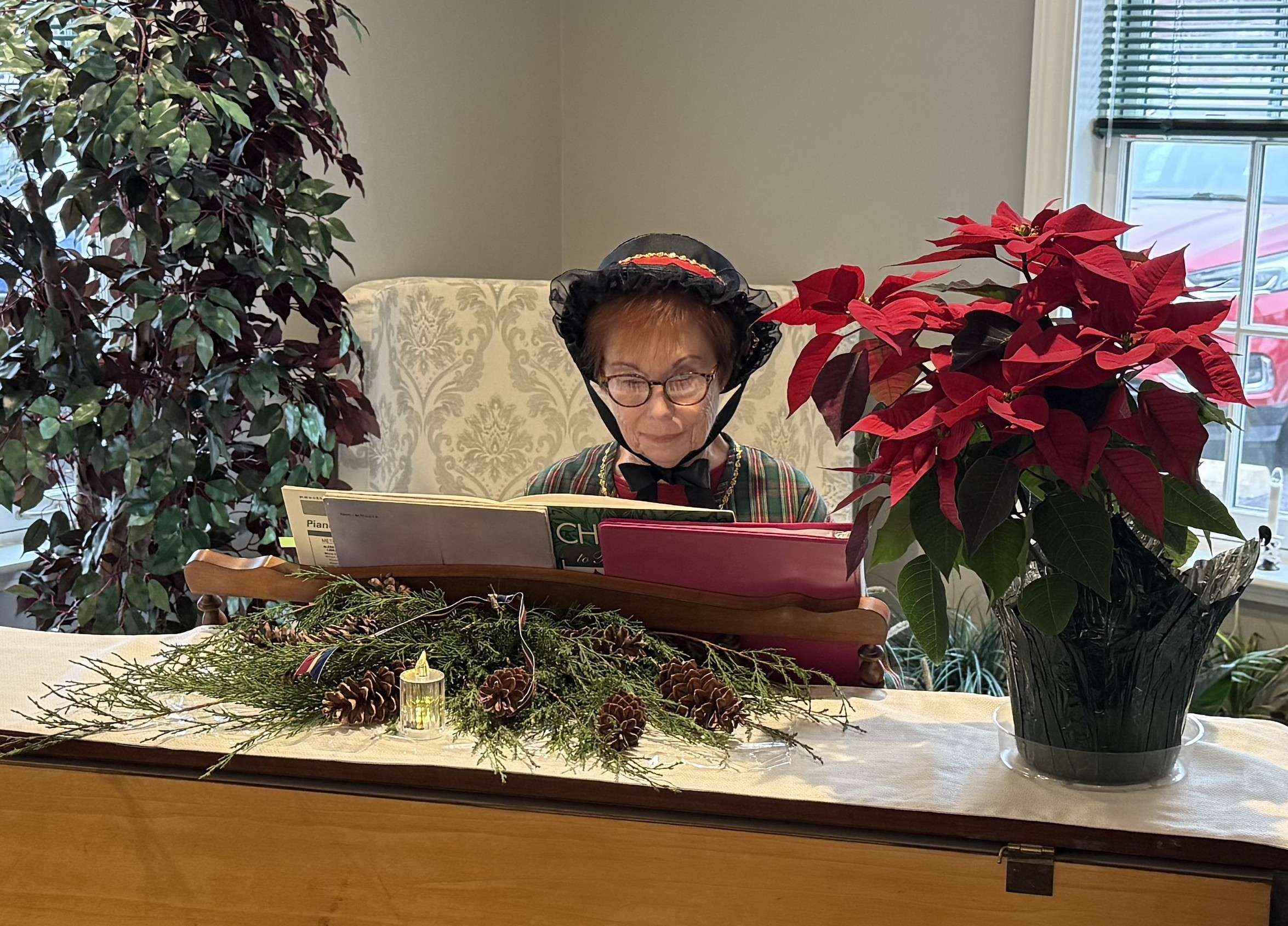 A woman in period dress at the piano during an earlier Christmas Tea