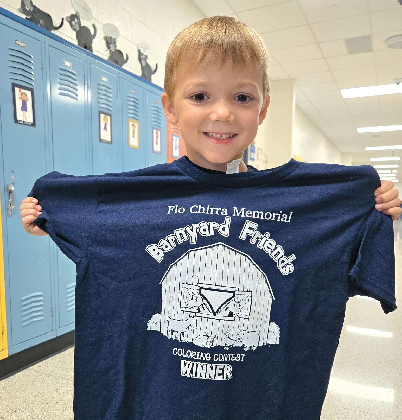 Callan Schoen, a Stryker kindergartner, holds up a Flo Chirra Memorial Barnyard Friends Coloring Contest winner t-shirt